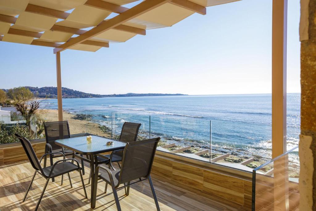 un patio con mesa y sillas y vistas al océano en Maritinas Apartment Sea View - Happy Rentals, en Katakolon