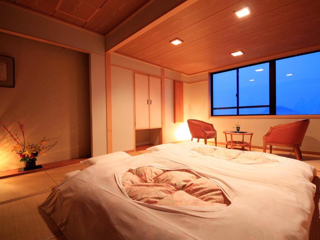 Postel nebo postele na pokoji v ubytování Hotel Tsubakino
