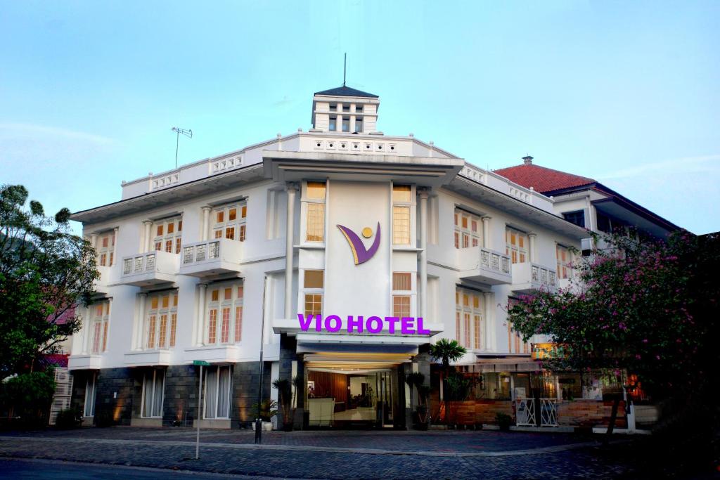 um edifício branco com um sinal de hotel em Vio Hotel Cimanuk Bandung em Bandung