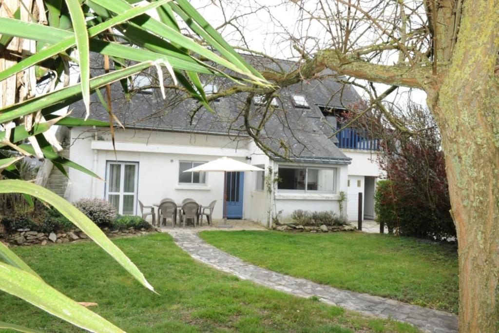 een wit huis met een tafel en stoelen in de tuin bij Maison côte sauvage classement 3 in Quiberon