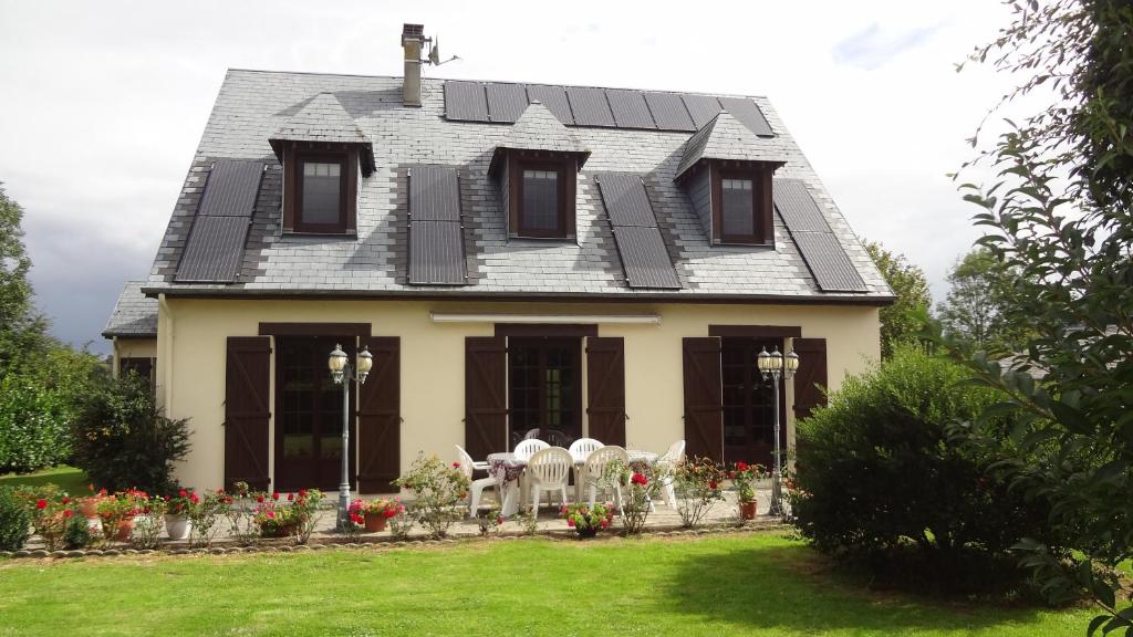 TrévièresにあるMaison de vacancesの灰色の屋根と花の家