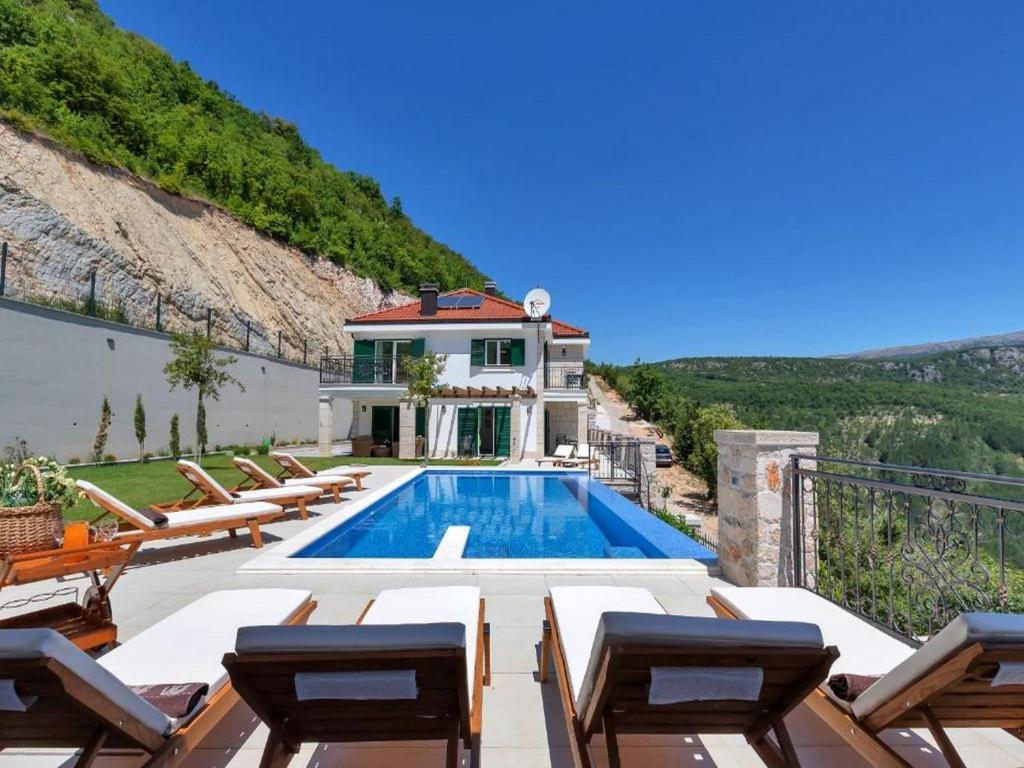 eine Villa mit einem Pool und einigen Stühlen in der Unterkunft Villa Finca Lazeta in Studenci