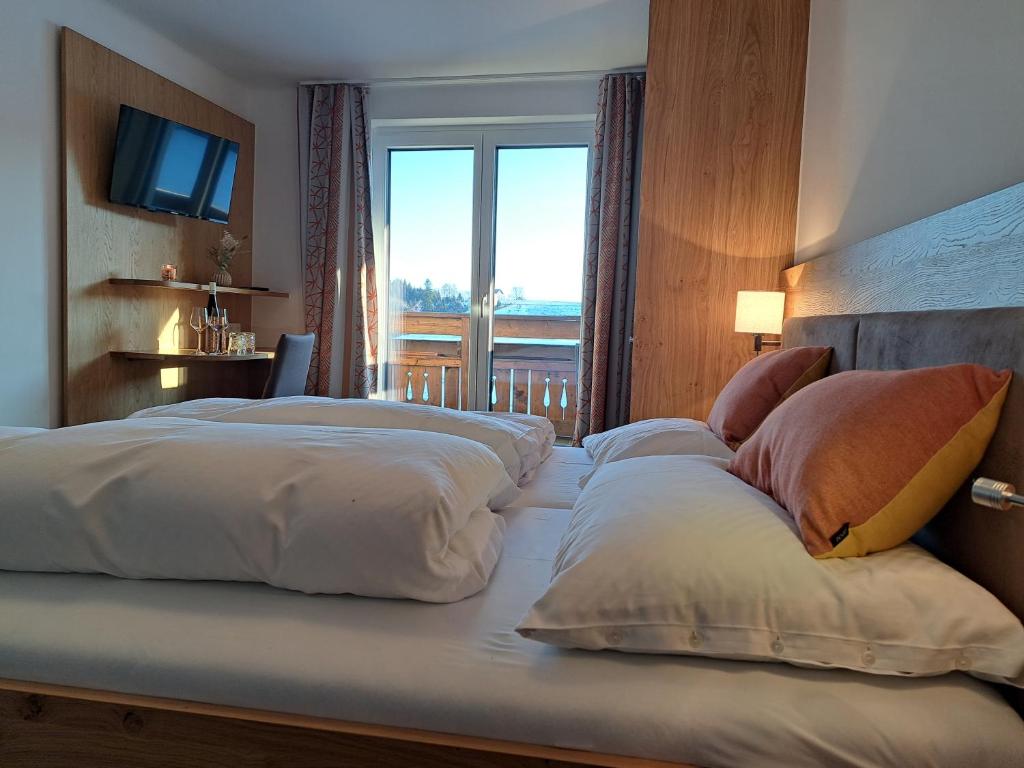 two beds in a hotel room with a window at Wirt in der Spöck in Neukirchen an der Vöckla