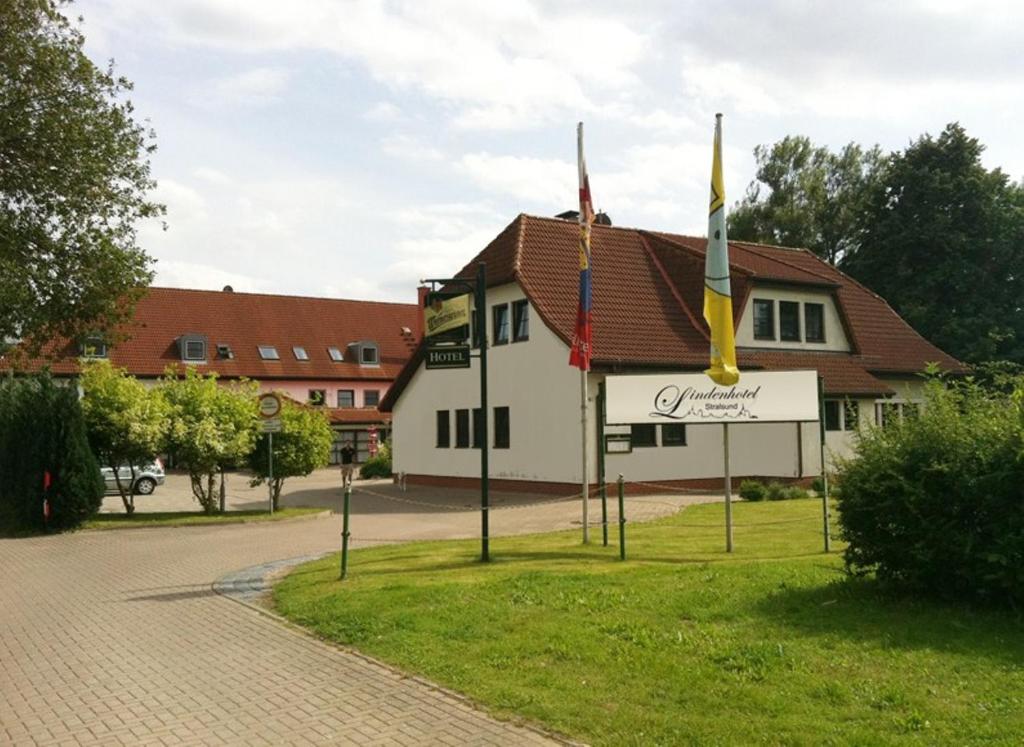 a building with flags in front of a street at Lindenhotel Stralsund in Stralsund