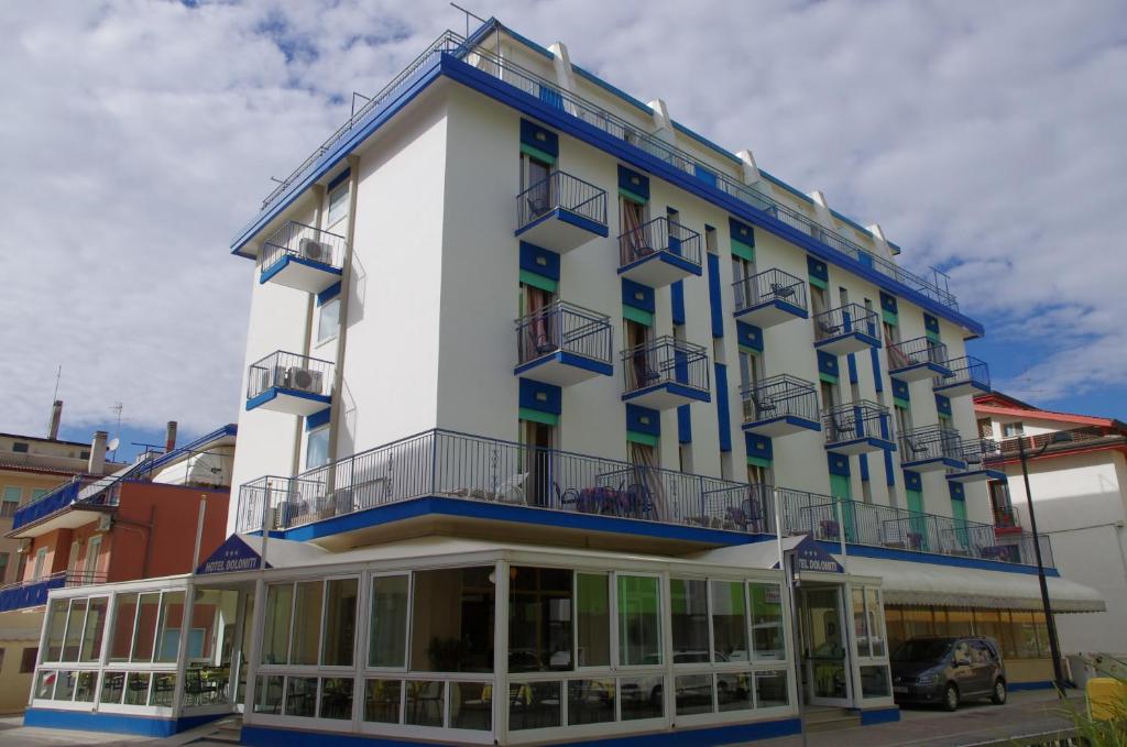 a large white building with balconies on top of it at Hotel Dolomiti in Caorle