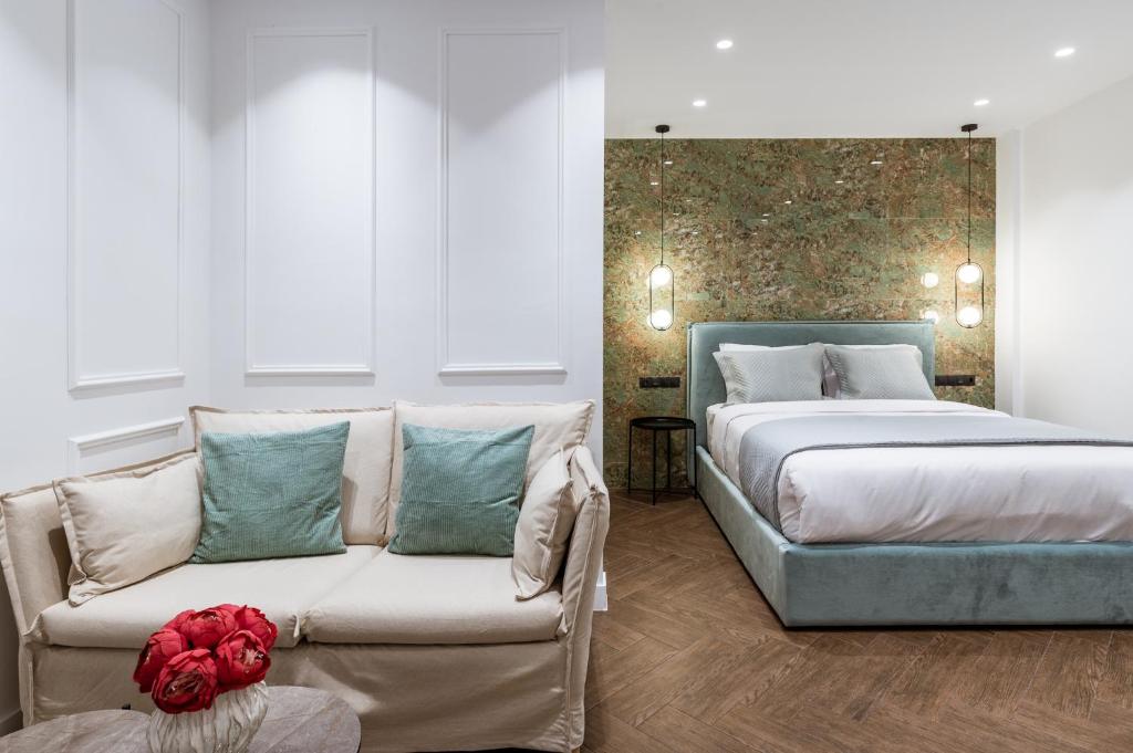 Phaedrus Living Luxury Studio Kolonaki Tsakalof في أثينا: غرفة نوم بسرير واريكة