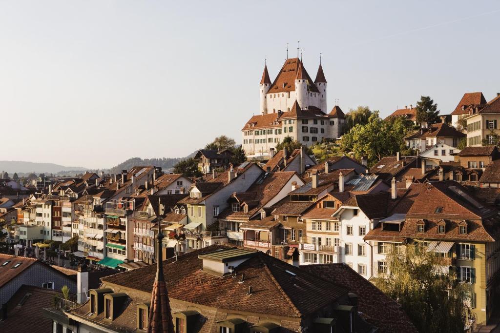 eine Stadt mit einem Schloss auf einem Hügel in der Unterkunft Boutique Hotel Schlossberg in Thun