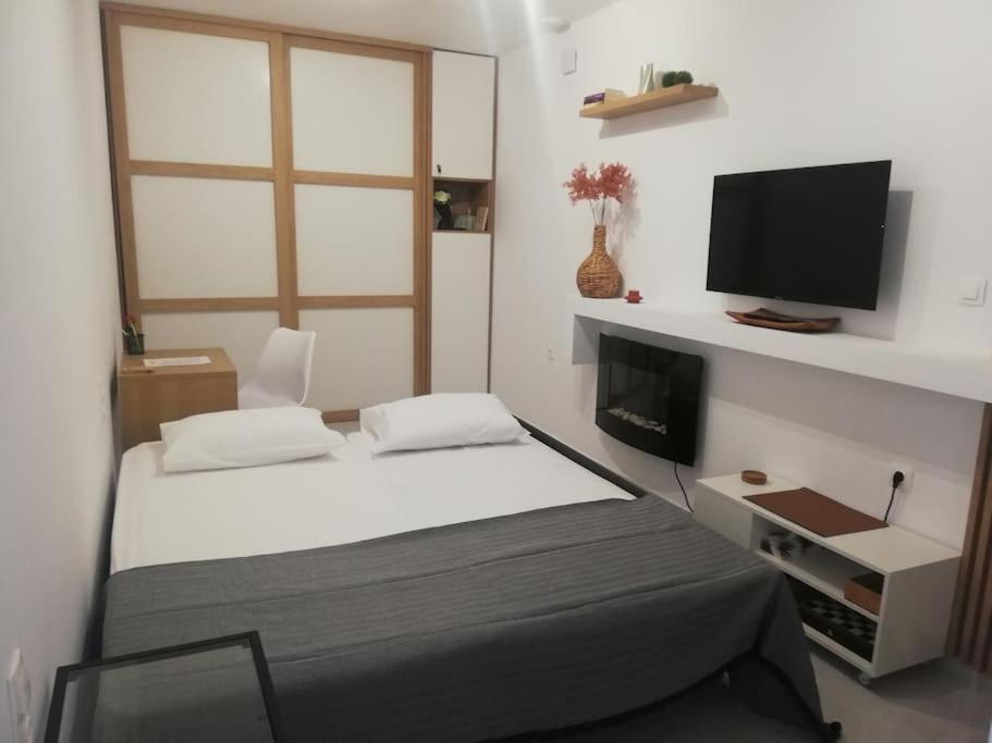 a bedroom with a bed and a flat screen tv at BRIO luxurious urban stay in Heraklio,WiFi,ΑC in Heraklio