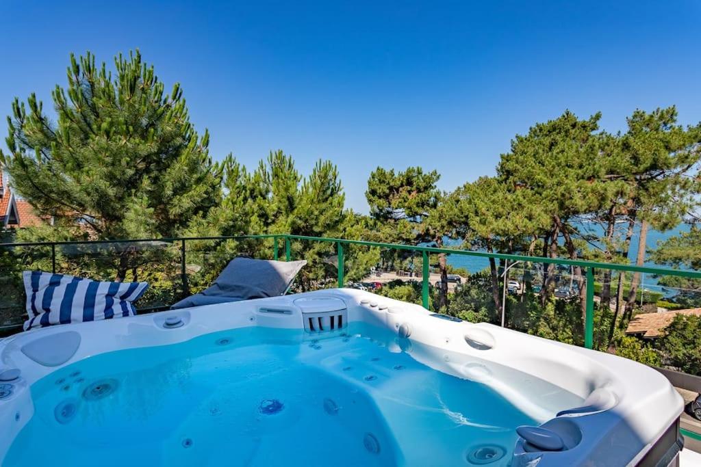 una vasca idromassaggio su un balcone con alberi sullo sfondo di O'DUNE Pyla Plage -appartement jacuzzi vue mer - a Pyla-sur-Mer