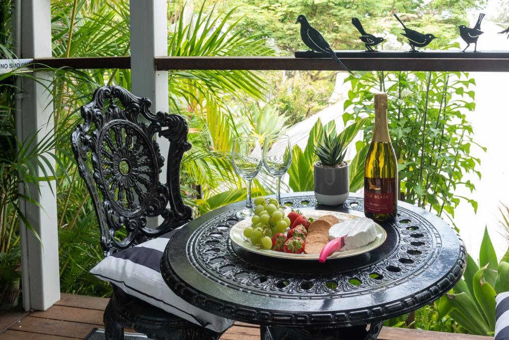 - une table avec une assiette de nourriture et une bouteille de vin dans l'établissement Contemporary Studio in the heart of Paddington, à Brisbane