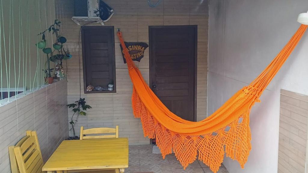 an orange hammock on the side of a house at Casinha guagiru in Trairi