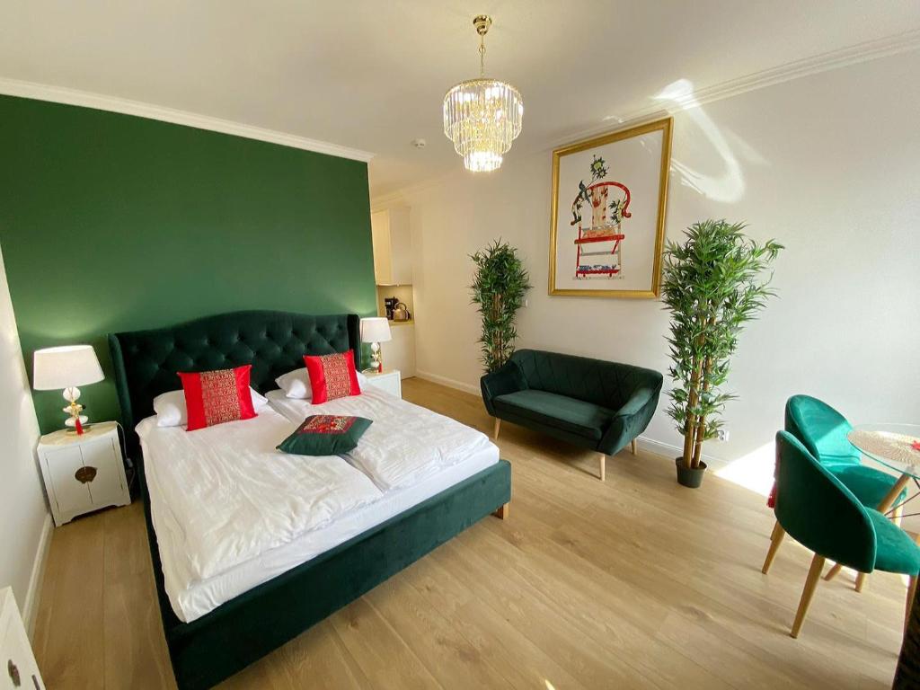a bedroom with a large bed and a green wall at Apartament Gdańsk Śródmieście Wałowa in Gdańsk