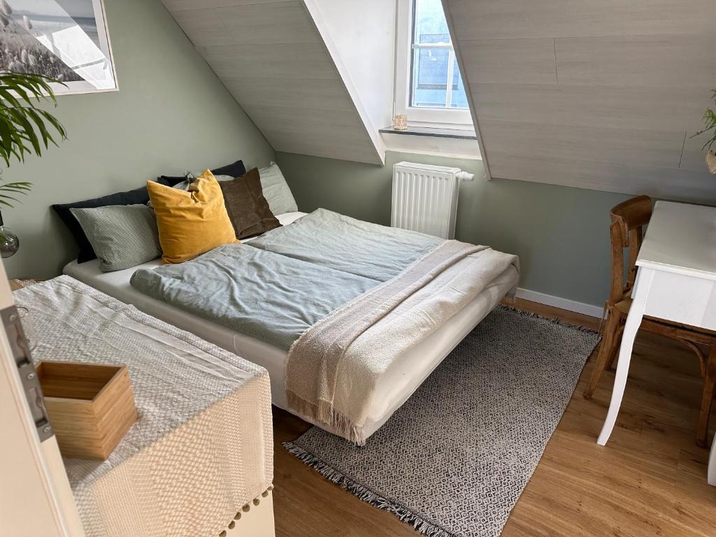 een kleine slaapkamer met een bed en een bureau bij Stilvolles Gästezimmer mit Bad in Mechernich-Zentrum in Mechernich
