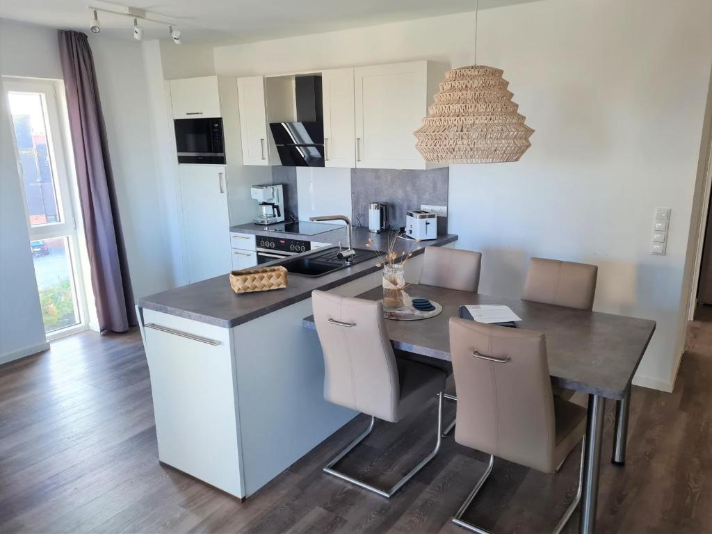 a kitchen with a table with chairs and a counter top at 50 3 N Nordkoje in Wangerland