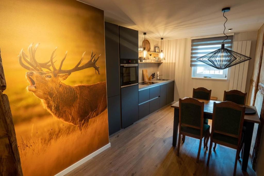 eine Küche und ein Esszimmer mit einem Hirschgemälde in der Unterkunft Ferienwohnung Rathausblick 2 in Blankenburg