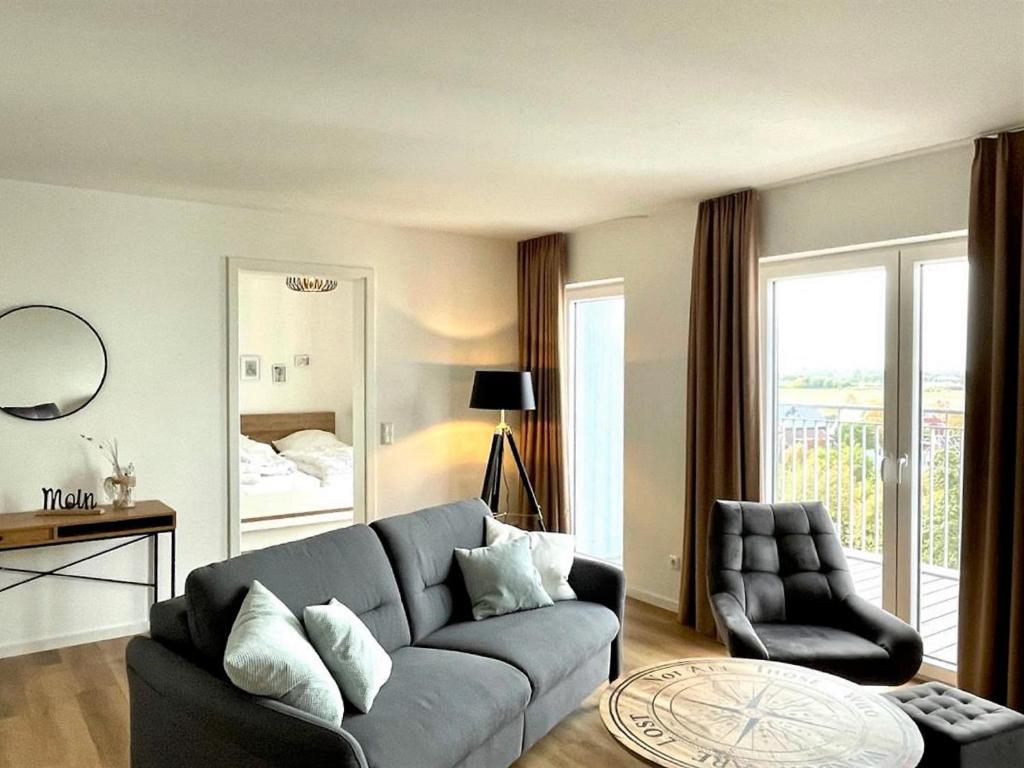 a living room with a couch and a chair at 49 5 M Ankerplatz in Wangerland