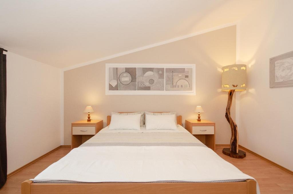 sypialnia z łóżkiem i 2 szafkami nocnymi w obiekcie Apartments Villa Amfora w Rovinj