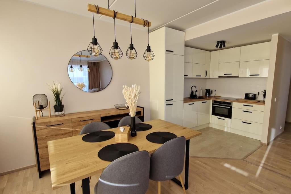 Il comprend une cuisine et une salle à manger avec une table et des chaises en bois. dans l'établissement Modern apartment with river view, à Tartu