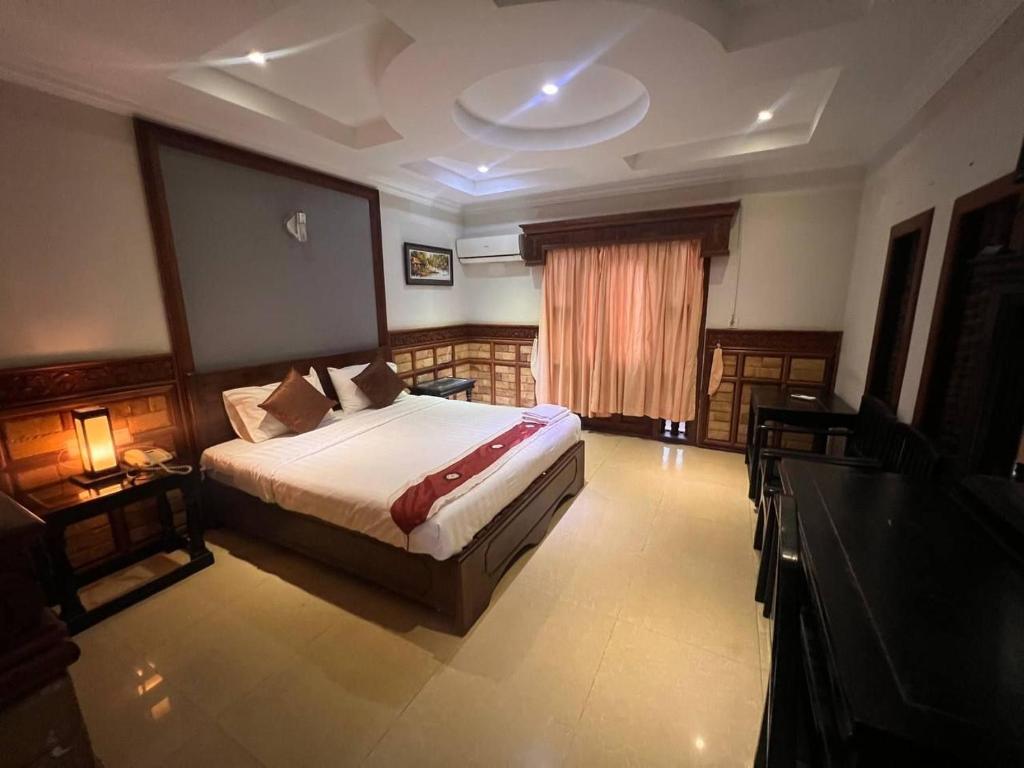 a hotel room with a bed and a window at Beat Hotel Siem Reap in Siem Reap