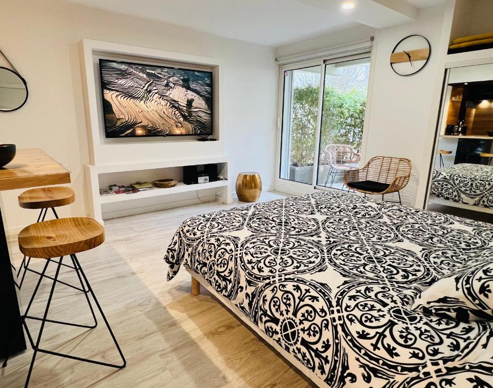 een slaapkamer met een zwart-wit bed en stoelen bij Feel@Home Nemausus « Le 42 » in Nîmes