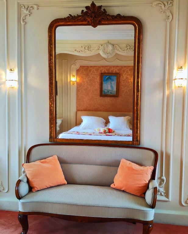 a mirror above a bed with a couch in a room at Domaine du Châtelard in Dirac