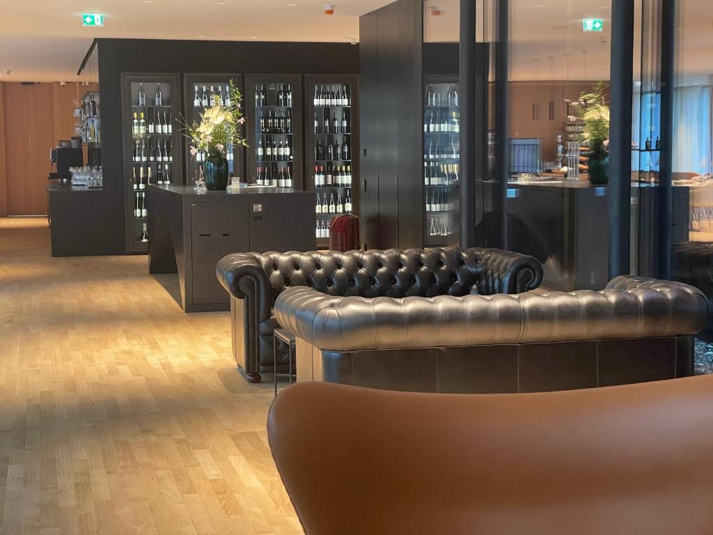 a bar with leather couches and bottles of wine at Das Flint in Dornbirn