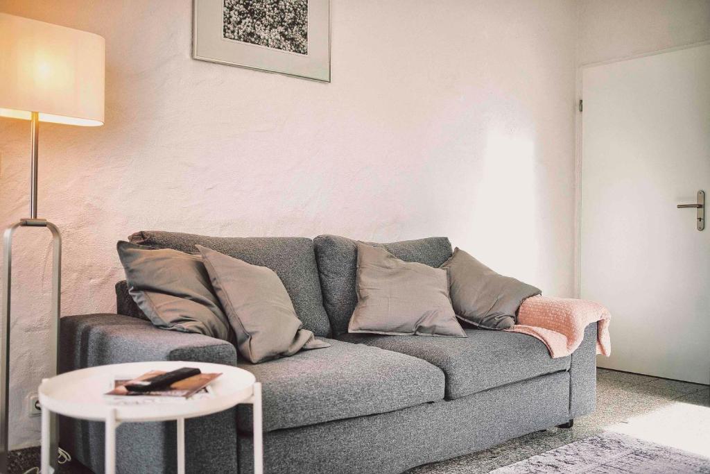 a living room with a gray couch and a table at Fritz' FeWo in Veldenz