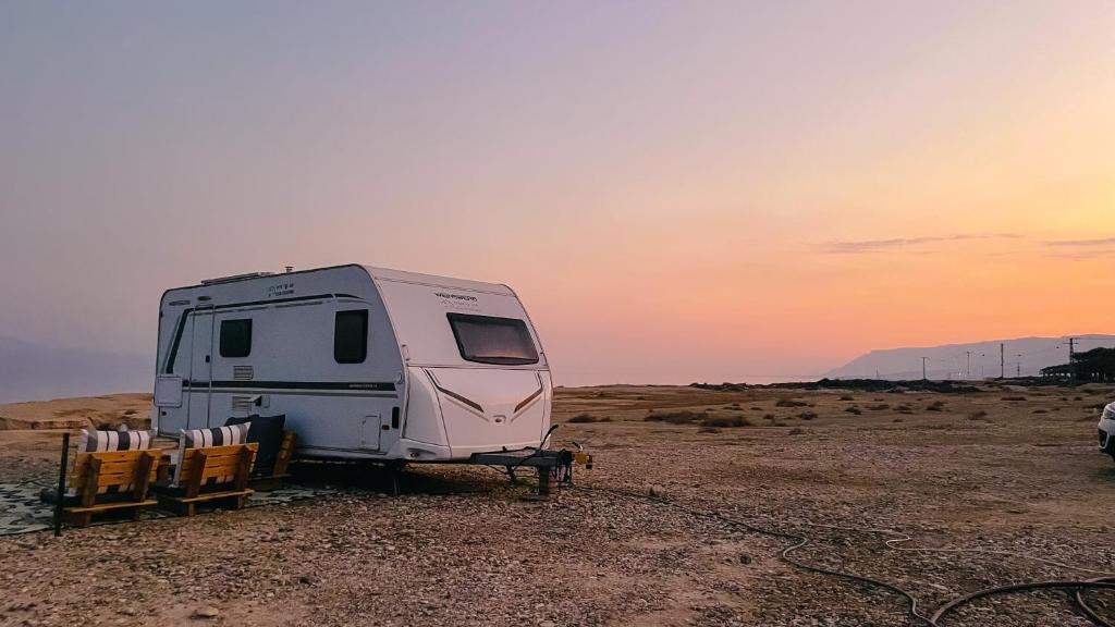 a camper parked in the desert at sunset at שלווה בים - צימר ים המלח, deadsea in Ovnat