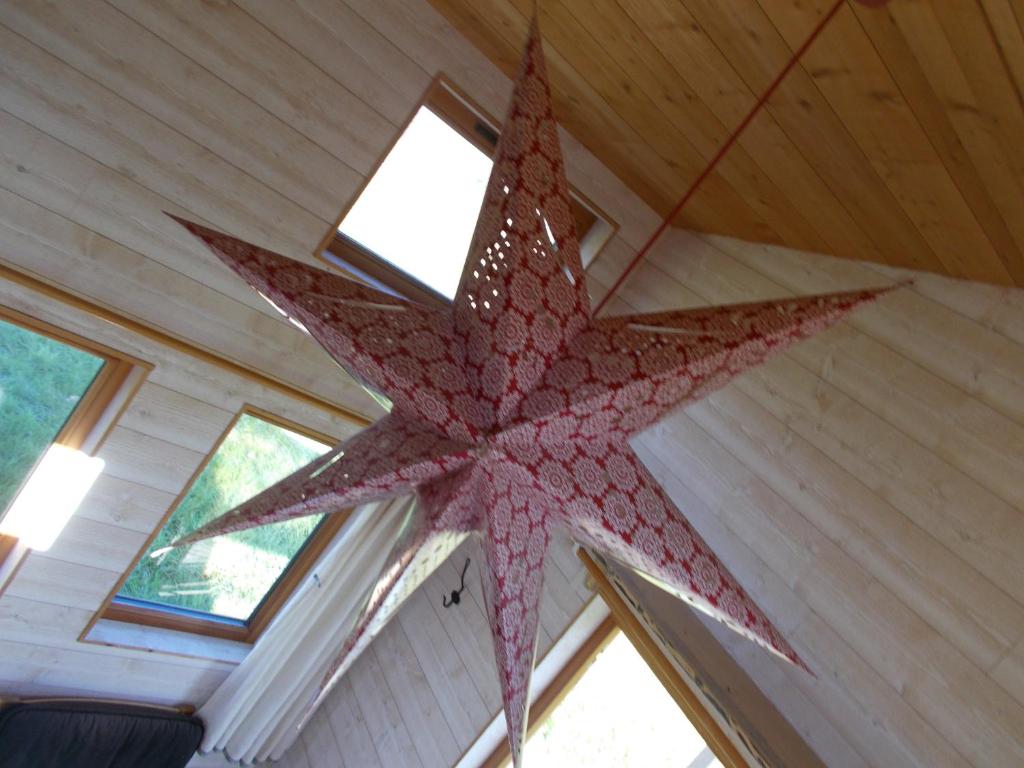 a large red star hanging from the ceiling of a room at Tiny House et yourte sous les Poiriers in Domfront