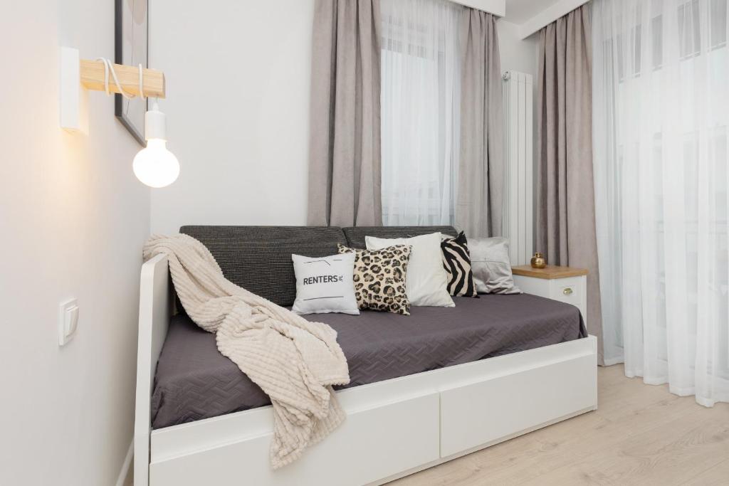 biała sypialnia z łóżkiem z poduszkami w obiekcie Warsaw Piaseczno Peaceful Apartment Cichej Łąki by Renters w Piasecznie