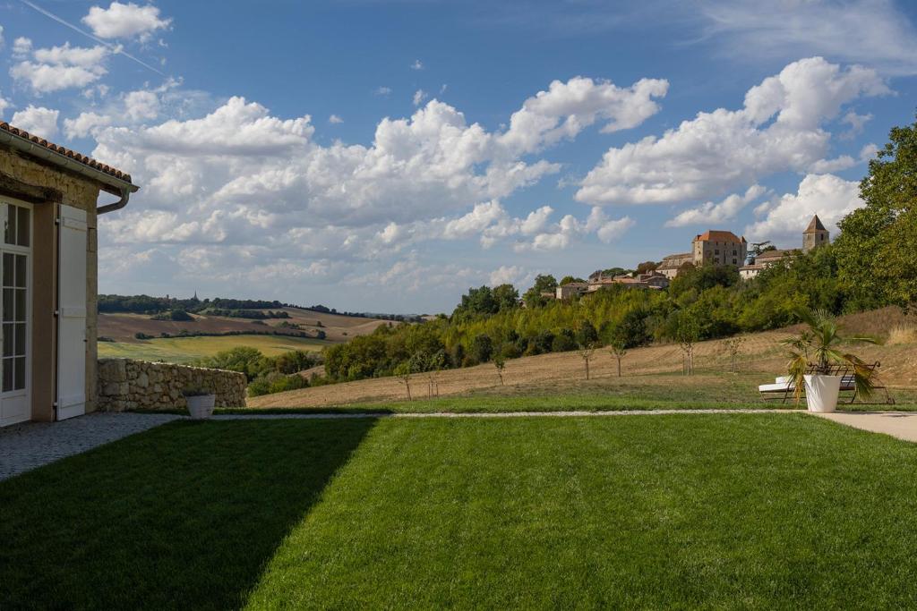 a view of a yard with a green lawn at Mas des Coteaux - vue panoramique - piscine - babyfoot - pingpong - pétanque &amp; espace enfants à 1h de MONTAUBAN in Gramont