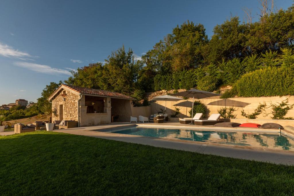 a backyard with a swimming pool and a house at Mas des Coteaux - vue panoramique - piscine - babyfoot - pingpong - pétanque &amp; espace enfants à 1h de MONTAUBAN in Gramont