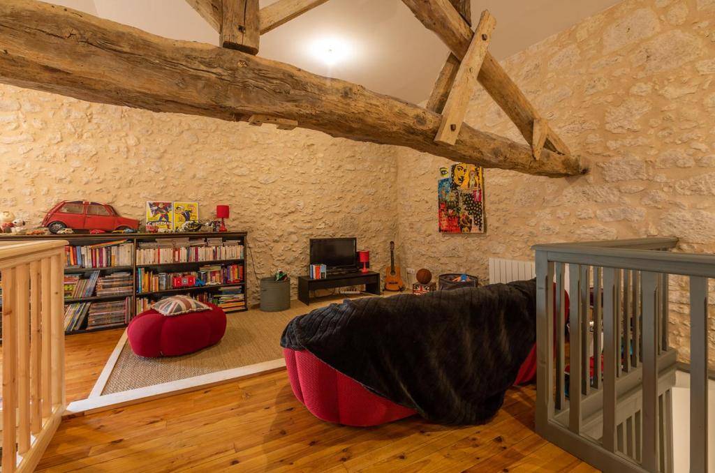 a living room with wooden floors and a brick wall at Mas des Coteaux - vue panoramique - piscine - babyfoot - pingpong - pétanque &amp; espace enfants à 1h de MONTAUBAN in Gramont