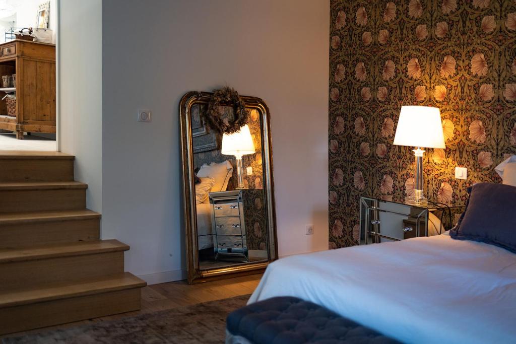 a bedroom with a mirror next to a bed at Mas des Coteaux - vue panoramique - piscine - babyfoot - pingpong - pétanque &amp; espace enfants à 1h de MONTAUBAN in Gramont