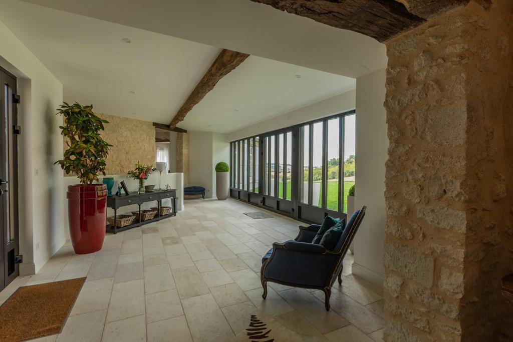 a large living room with a stone wall at Mas des Coteaux - vue panoramique - piscine - babyfoot - pingpong - pétanque &amp; espace enfants à 1h de MONTAUBAN in Gramont