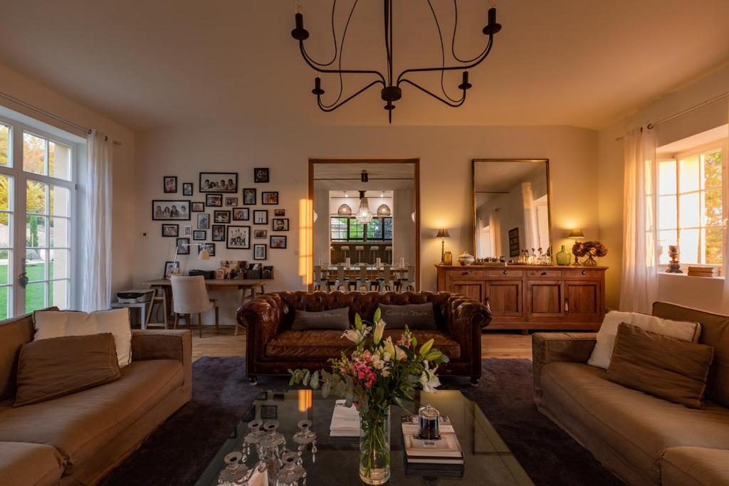 a living room with couches and a table at Mas des Coteaux - vue panoramique - piscine - babyfoot - pingpong - pétanque &amp; espace enfants à 1h de MONTAUBAN in Gramont