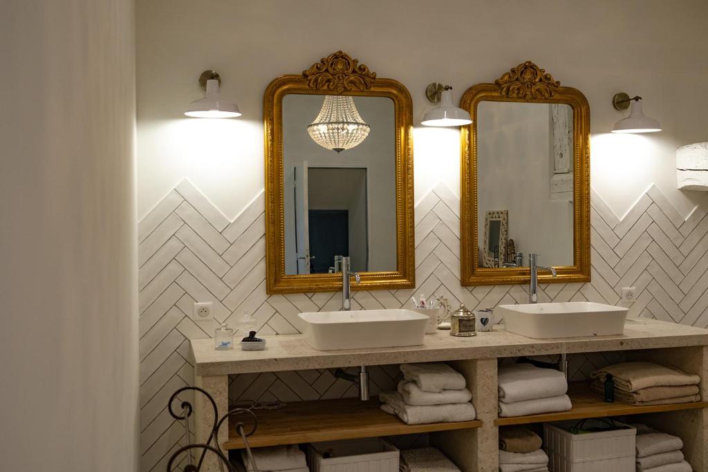 a bathroom with two sinks and two mirrors at Mas des Coteaux - vue panoramique - piscine - babyfoot - pingpong - pétanque &amp; espace enfants à 1h de MONTAUBAN in Gramont