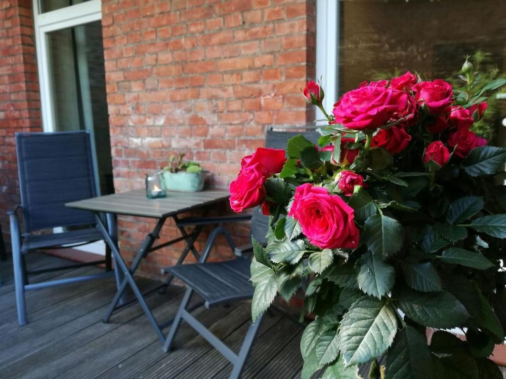 a table and a bouquet of roses on a patio at Stadtgärtchen in Lüneburg