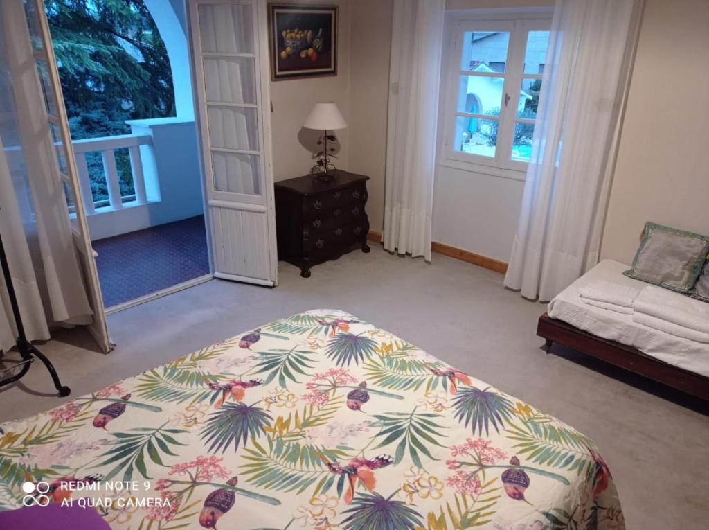 ein Schlafzimmer mit einem Bett, einem Sofa und einer Tür in der Unterkunft La maison basque in Sainte-Livrade-sur-Lot