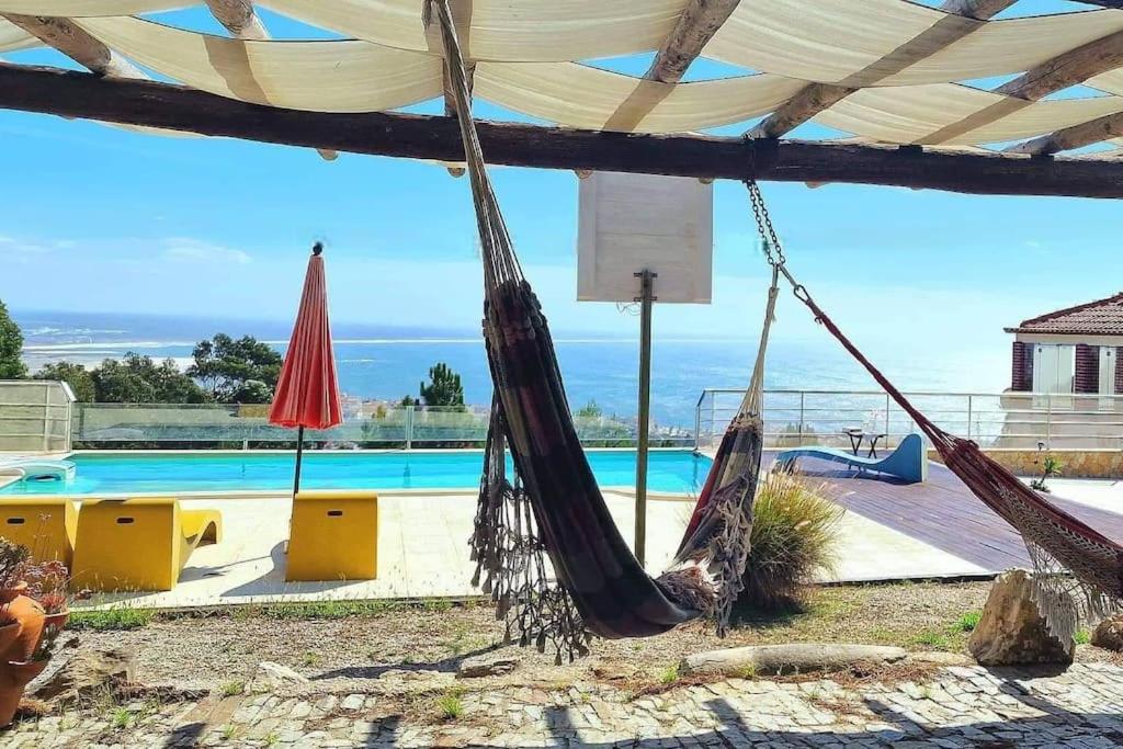 een patio met 2 hangmatten en een zwembad bij Casa na Floresta in Figueira da Foz