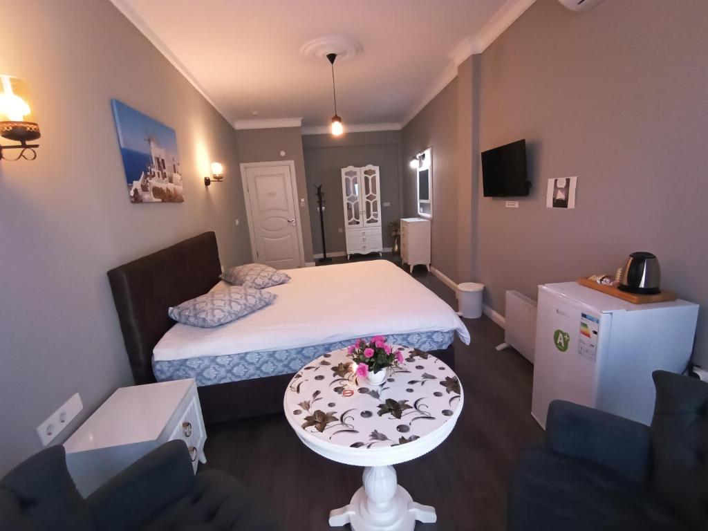 Habitación pequeña con cama y mesa con flores. en Lebon Little Palace Blue, en Estambul
