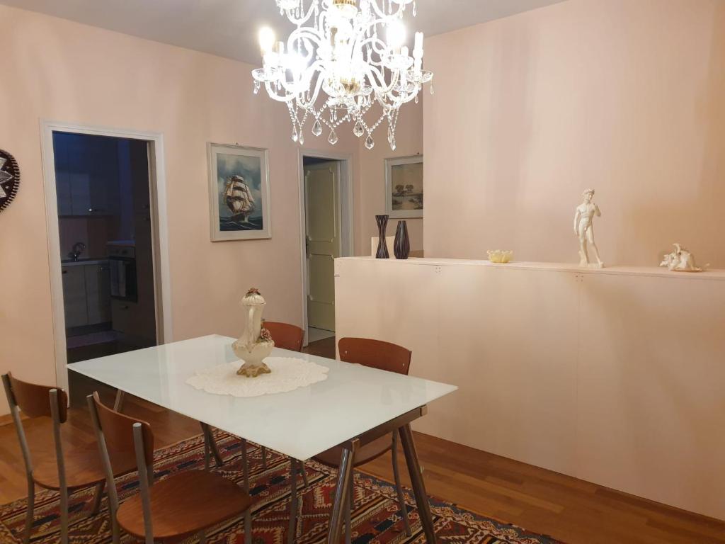 ein Esszimmer mit einem weißen Tisch und Stühlen in der Unterkunft Appartamento duplex in Carpi