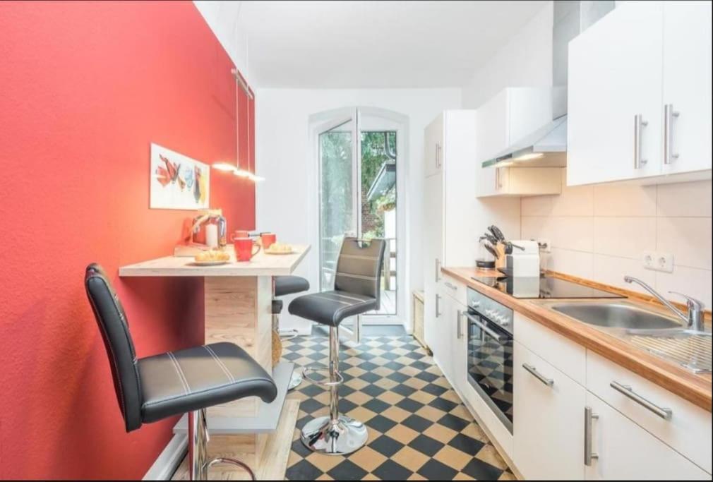 a kitchen with a counter and two chairs in it at City Apartment Lüneburg in Lüneburg