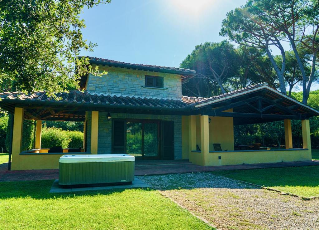 une maison avec une poubelle dans la cour dans l'établissement Ville Di Villa Biserno, à San Vincenzo