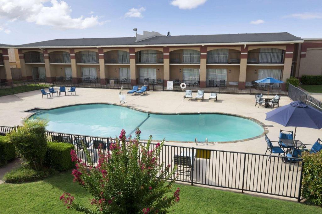 a large pool in front of a building at Howard Johnson by Wyndham Oklahoma City OKC Airport, Near Fairgrounds, I40, Free Hot Breakfast, and Pool in Oklahoma City