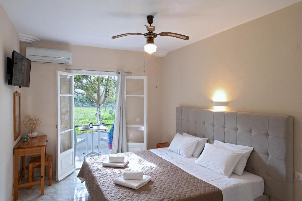 a bedroom with a bed and a door to a patio at Damaskis Kassiopi Studios in Kassiopi