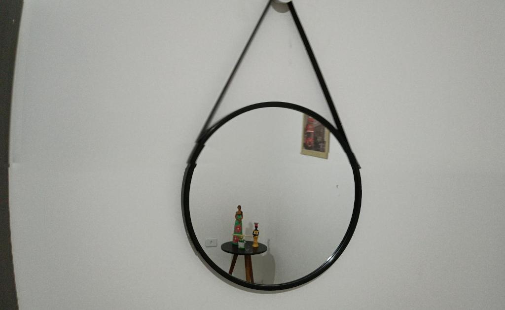 un espejo colgado en una pared con una mesa en Residencial Alto Xurupita en Porto Seguro