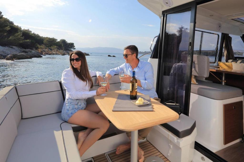 a man and woman sitting at a table on a boat at SuiteOnBoat in Naples