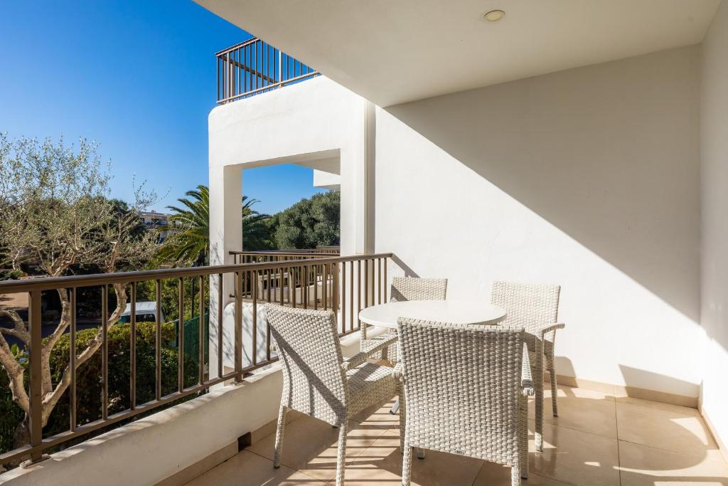 eine Terrasse mit einem Tisch und Stühlen auf dem Balkon in der Unterkunft Apartamento Aquamarina 5 in Cala Ferrera