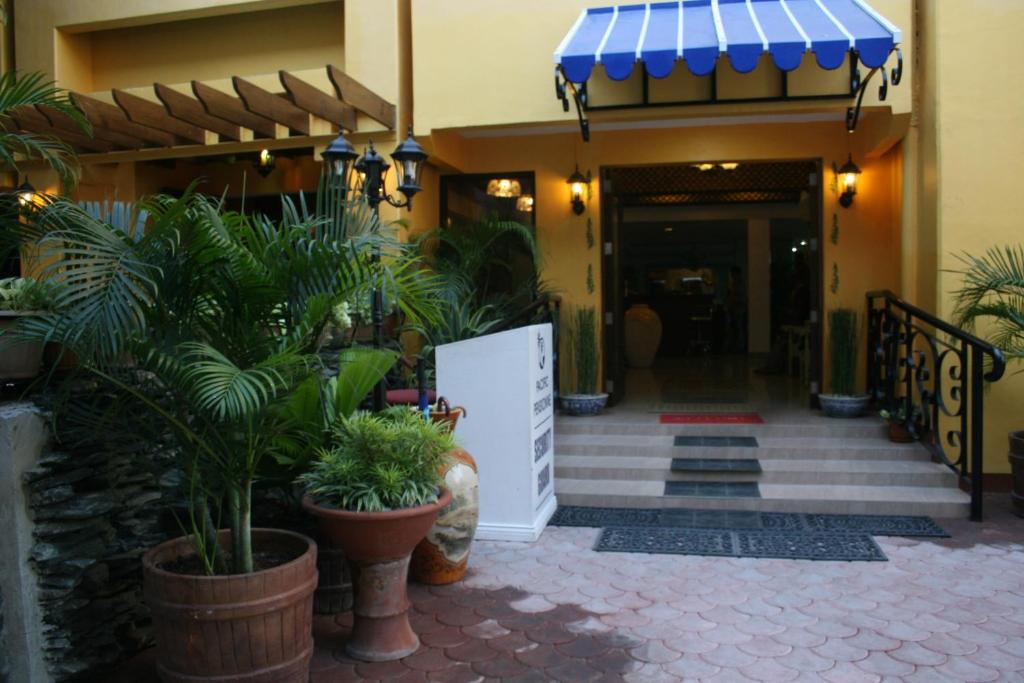 a building with a blue awning and some plants at Pacific Pensionne in Cebu City